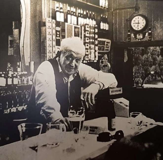 old image of bill chawke behind the bar